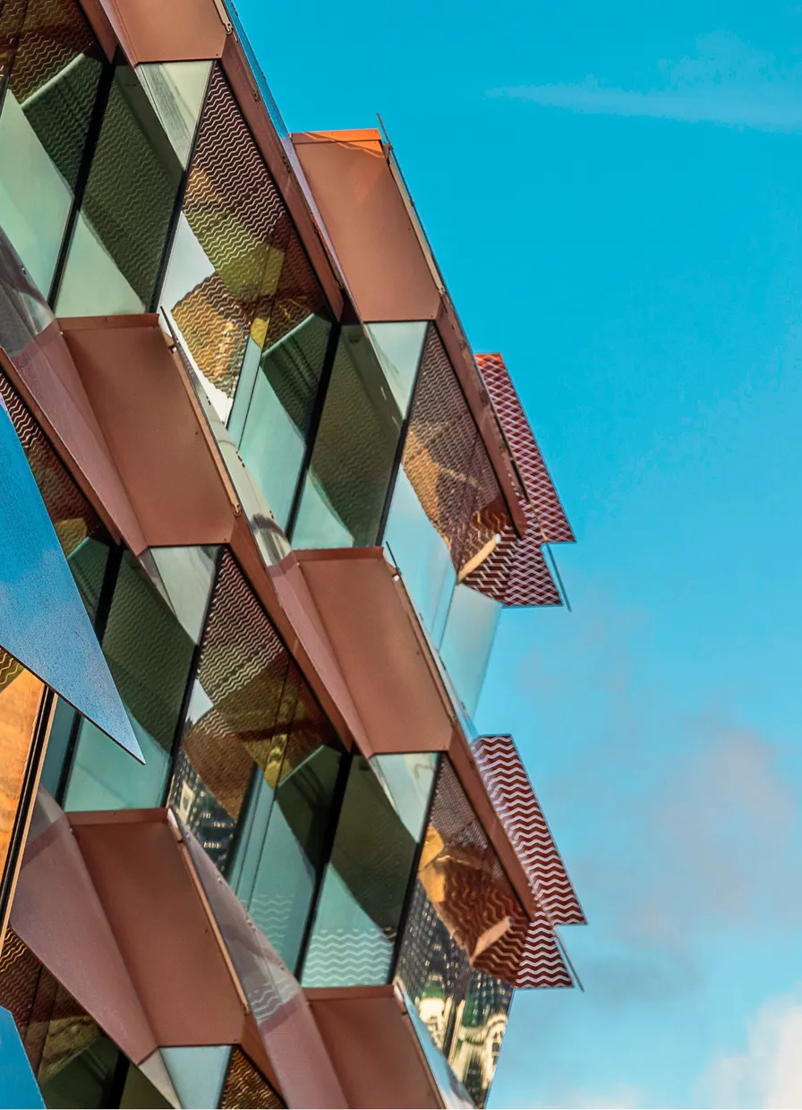 Facadepaneler i kobber og glas på Østerport II mod en blå himmel