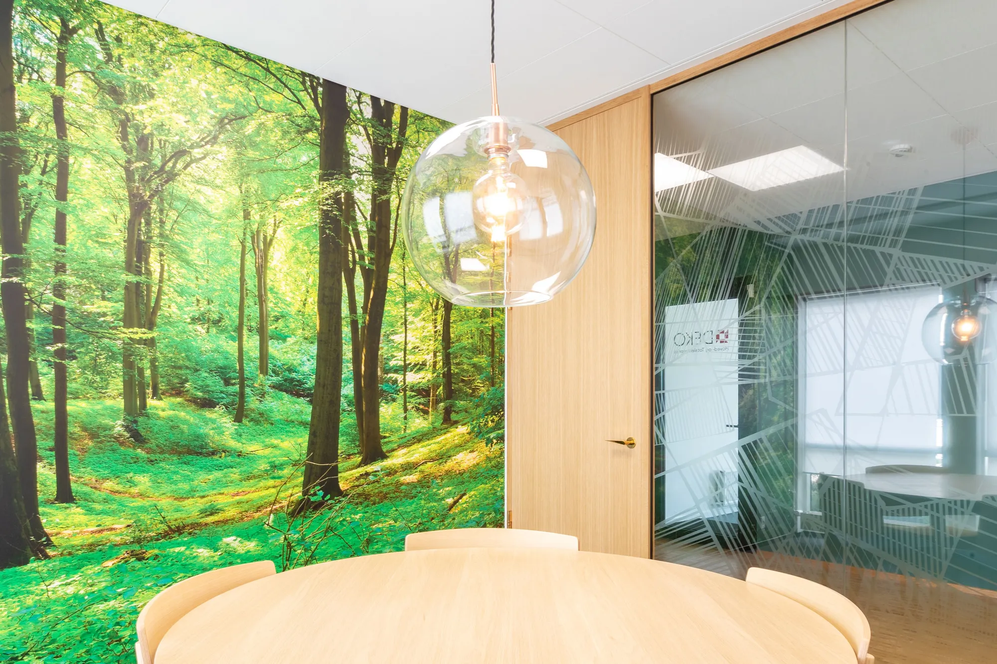 Fully glazed partition in minimal wooden design invites nature into the office interiors