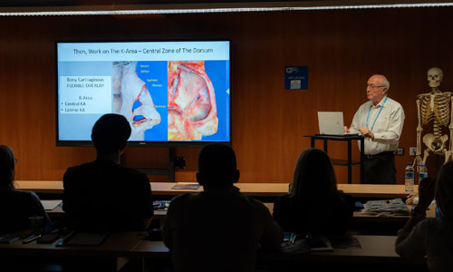 Participants in front of the speaker and screen with information about the K-Zone (central zone of the Dorsum)