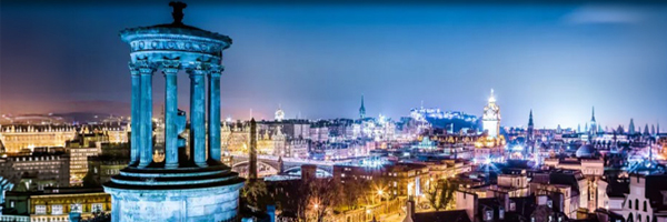 Illuminated Old Town of Edinburgh with numerous historic buildings.