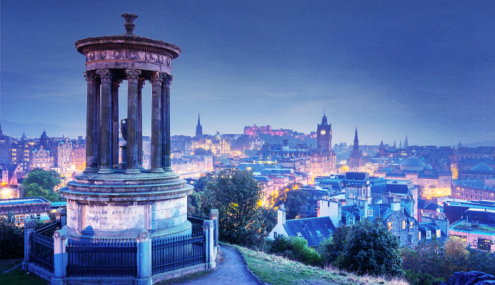 Illuminated Old Town of Edinburgh with numerous historic buildings.