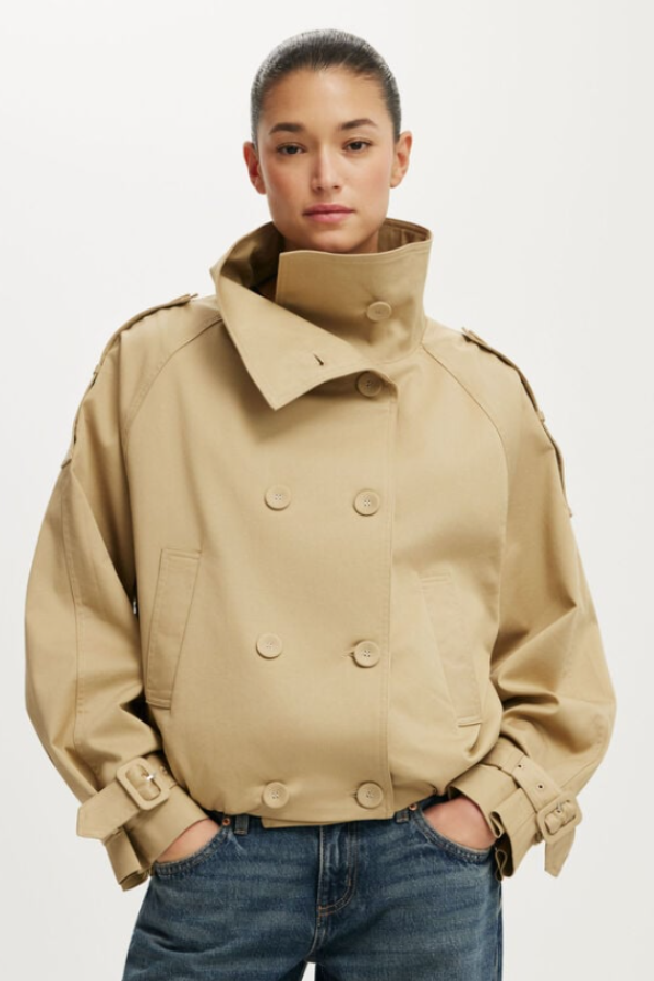 A cropped trench coat cut in a cotton-blend fabric with a regular fit and straight hem. The full sleeves and clean silhouette keep the shape polished and easy. A lined construction adds a neat finish throughout.