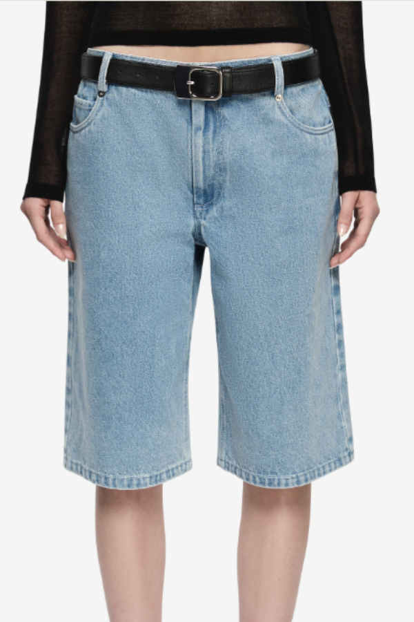 Teo Short in Classic Blue. A wide-leg denim short that sits at the knee with a thin adjustable self belt and silver hardware, featuring belt loops, two inseam pockets, and two back patch pockets.