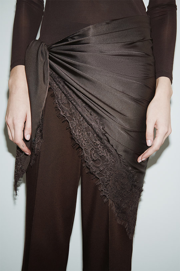 Large triangular scarf in softly draping satin. Features a lace trim along two sides.
