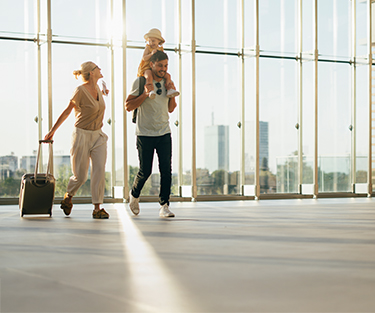 Vater, Mutter und Kind freuen sich auf den gemeinsamen Flug in den Urlaub.
