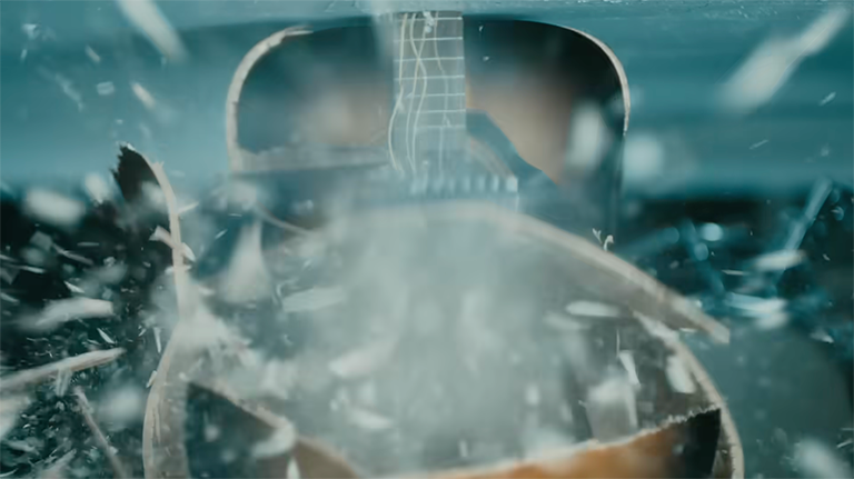 A guitar exploding - still frame from Apple’s video.