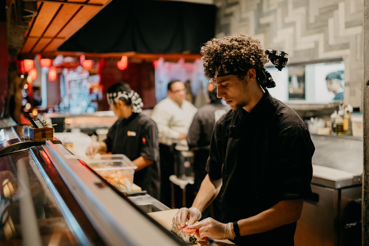 Hospitality team members collaborating during a shift in a restaurant kitchen
