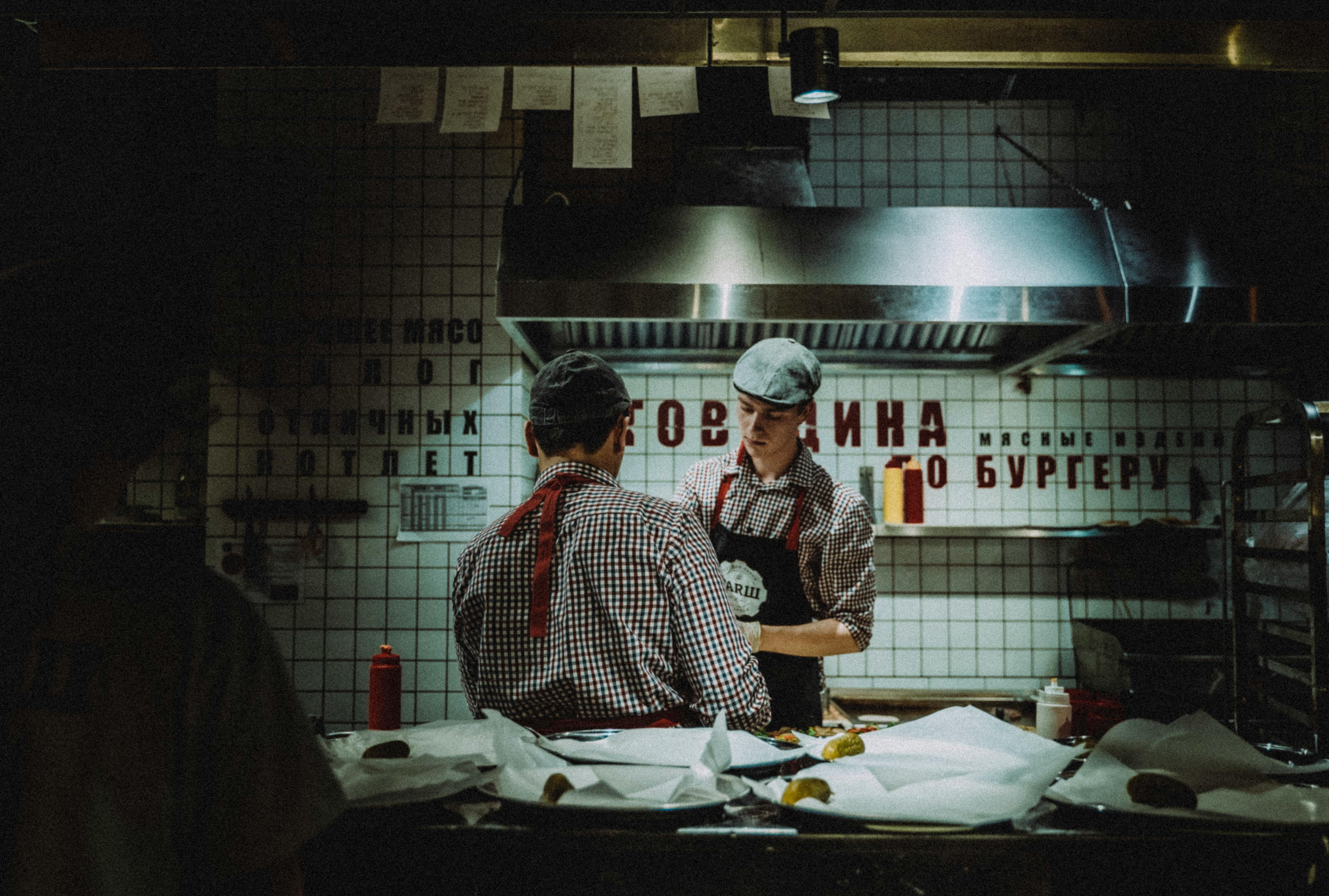 Restaurant kitchen staff collaborating during a busy service