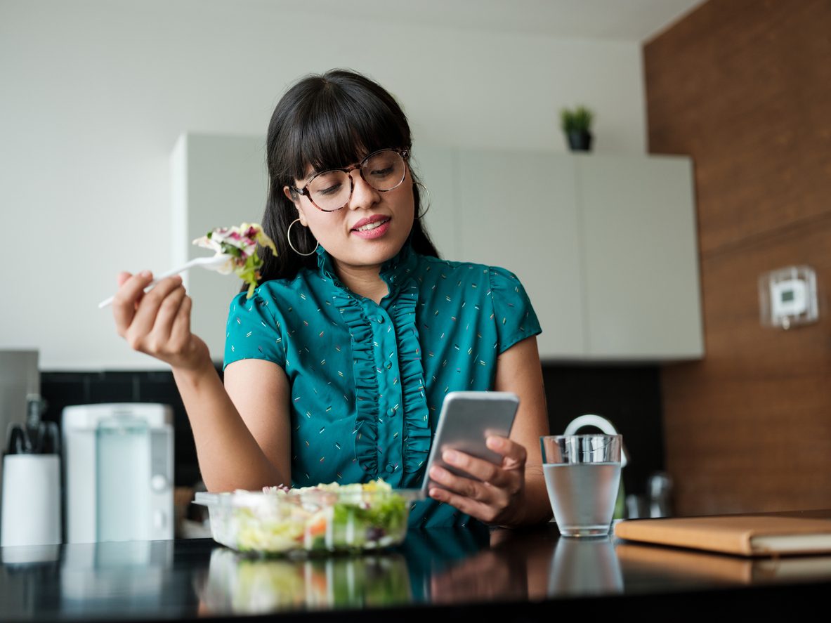 woman eating salad during work lunch break
