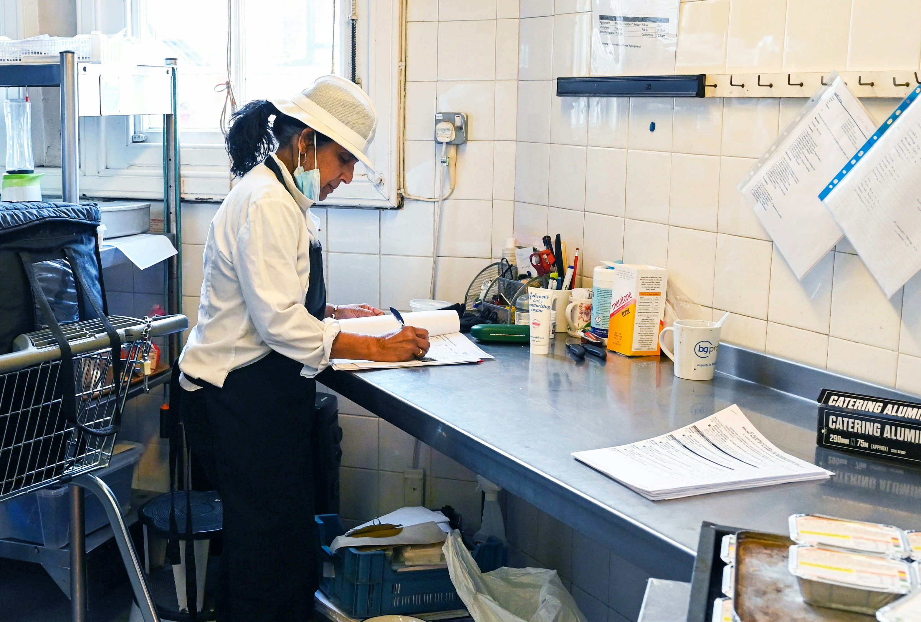 Hospitality manager reviewing shift plans to manage overtime on a UK rota