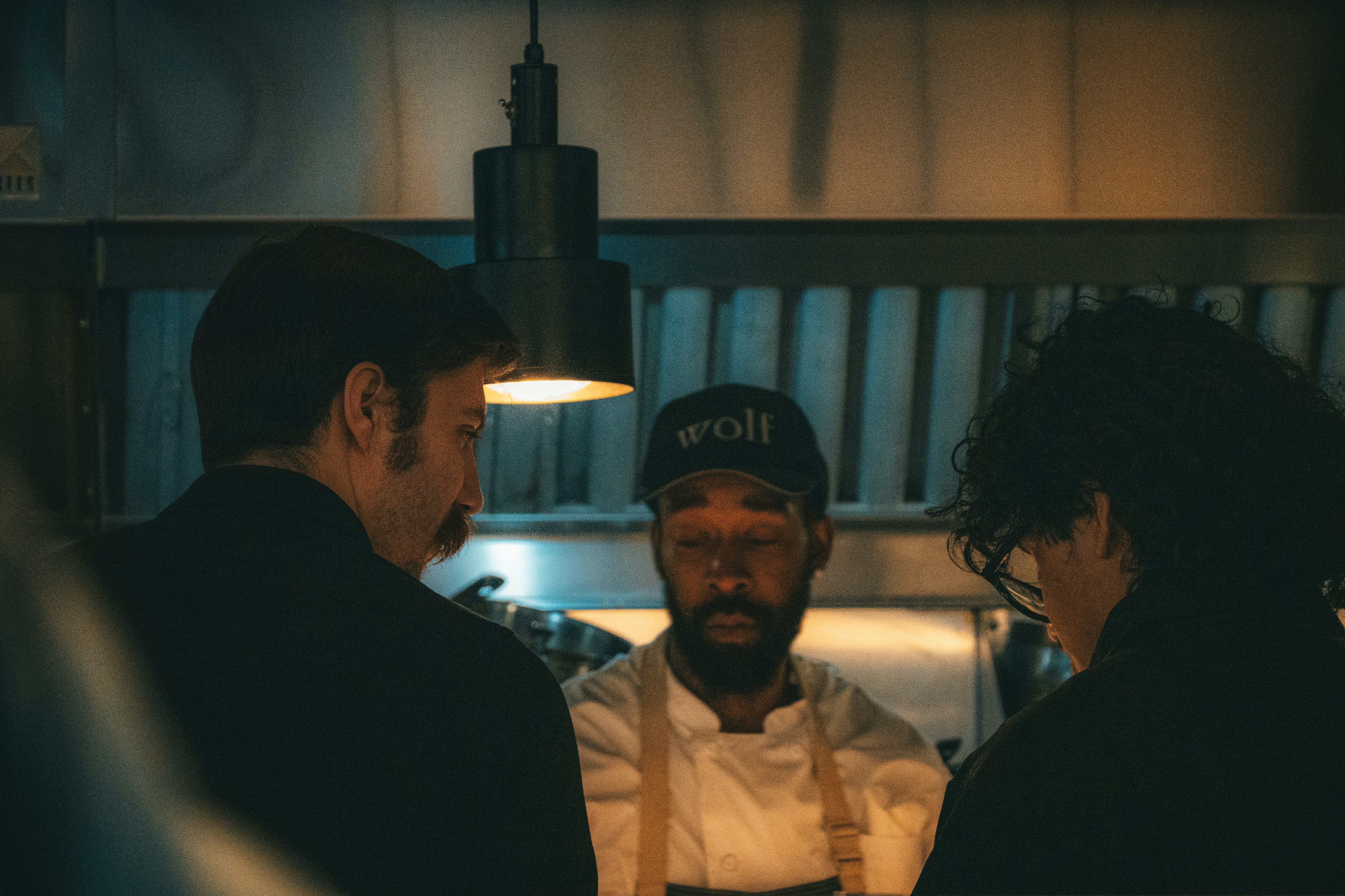 Chefs collaborating in a busy restaurant kitchen during a shift change