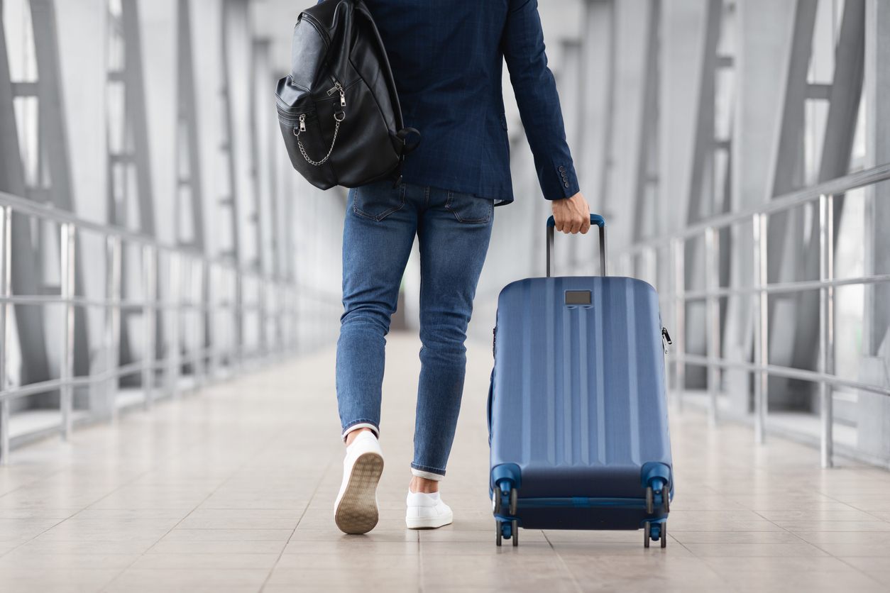 Unrecognizable Man With Bag And Suitcase Walking