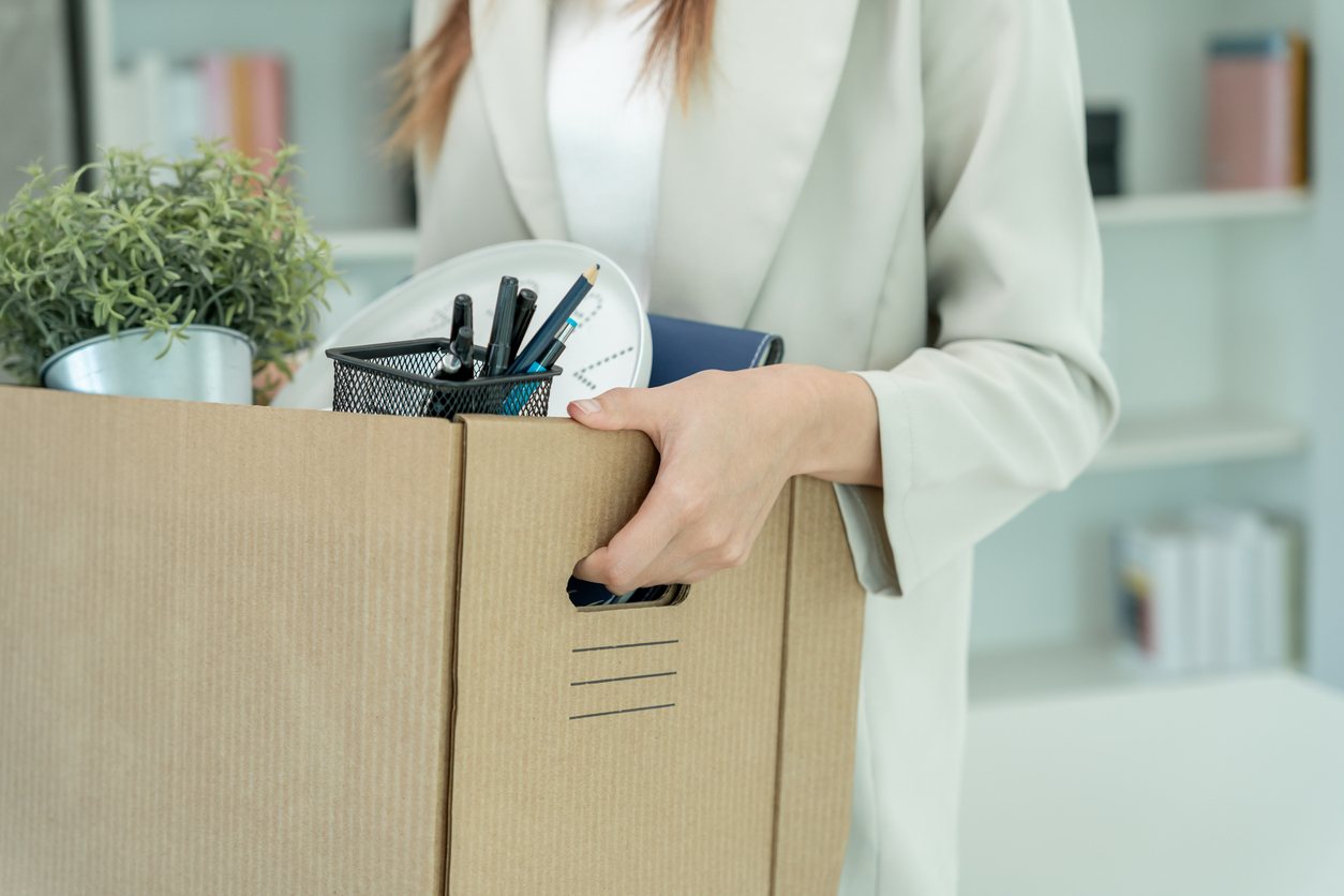 office employee packing up office supplies into cardboard box