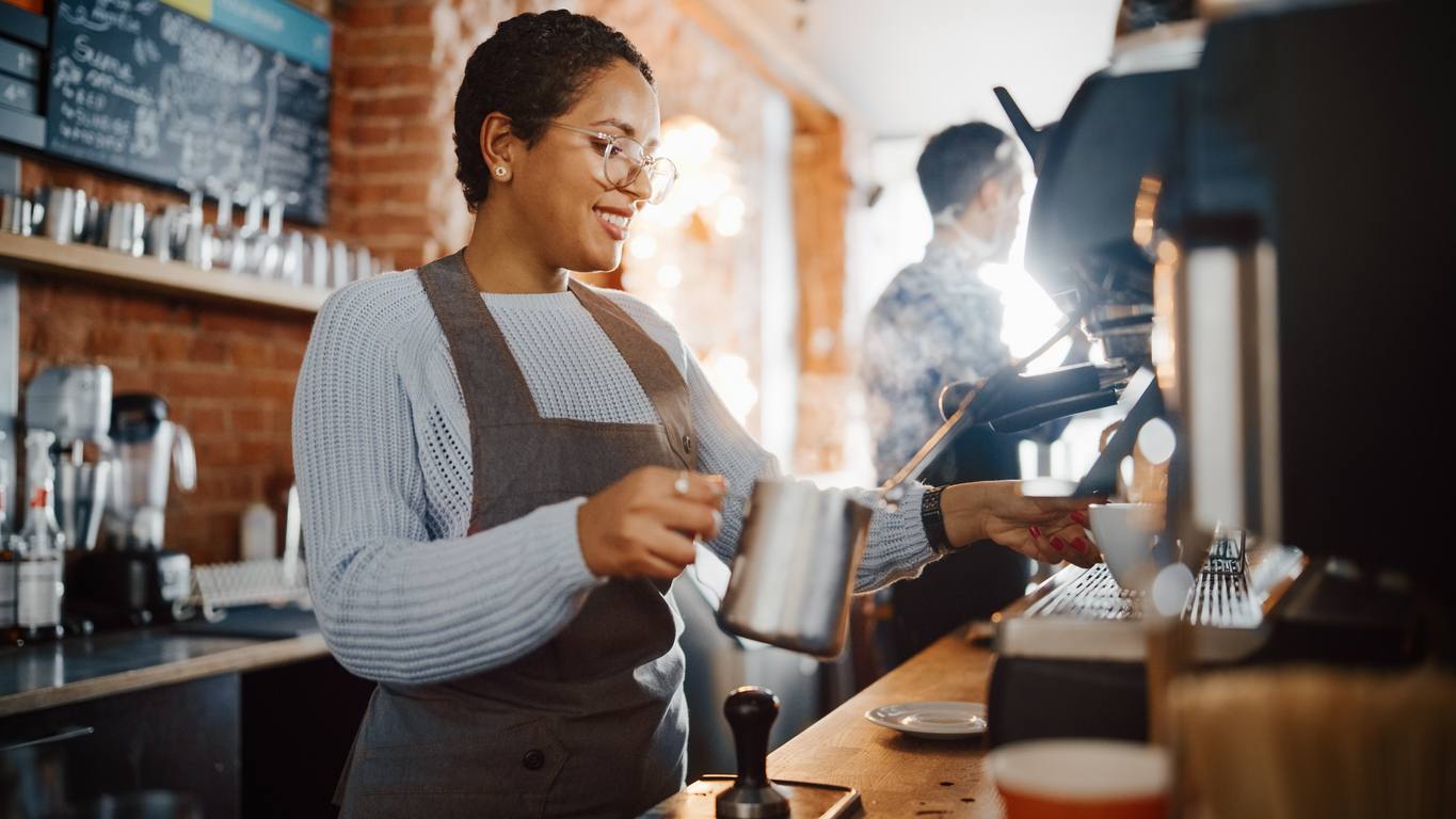 female barista working at espresso machine