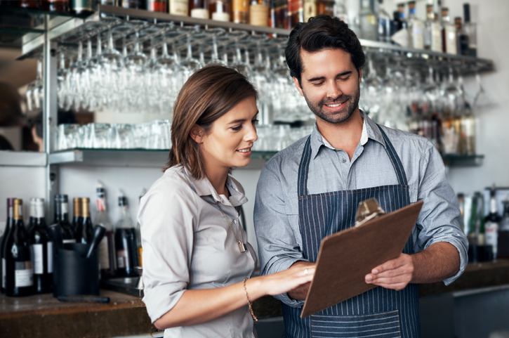 two employees reviewing clipboard