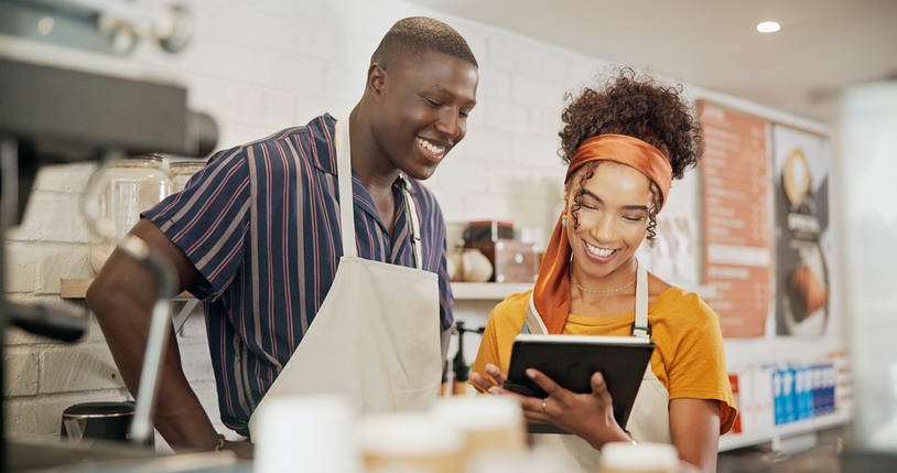 barista employee and manager looking at ipad reviewing info
