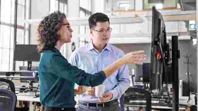 Construction team discussing progress onsite using mobile construction technology in the field.