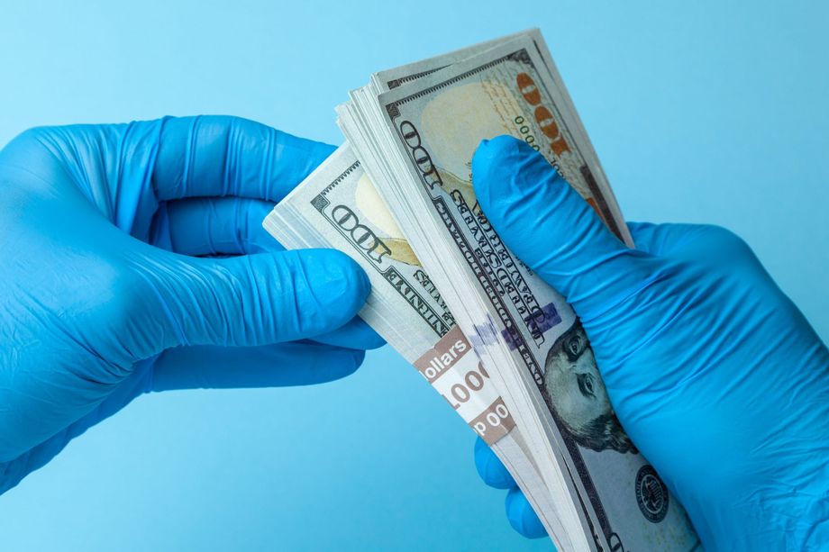 Holding cash wearing medical gloves