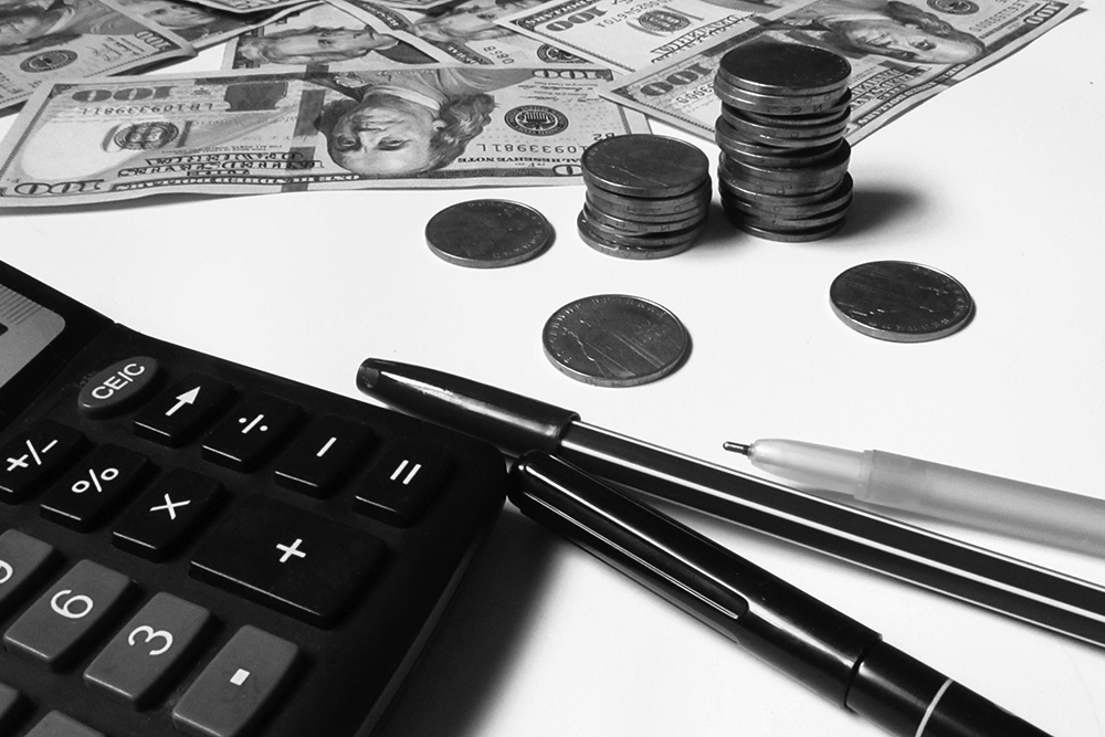 Cash and coins lie near a calculator.