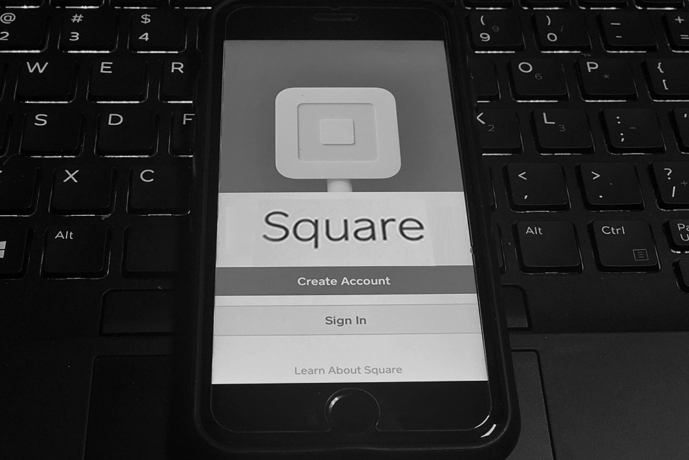 Phone with a Square app on a POS keyboard.