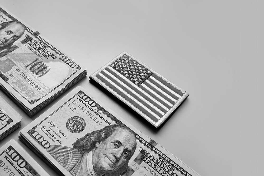 Stacks of cash in neat rows next to a stack of U.S. flag patches