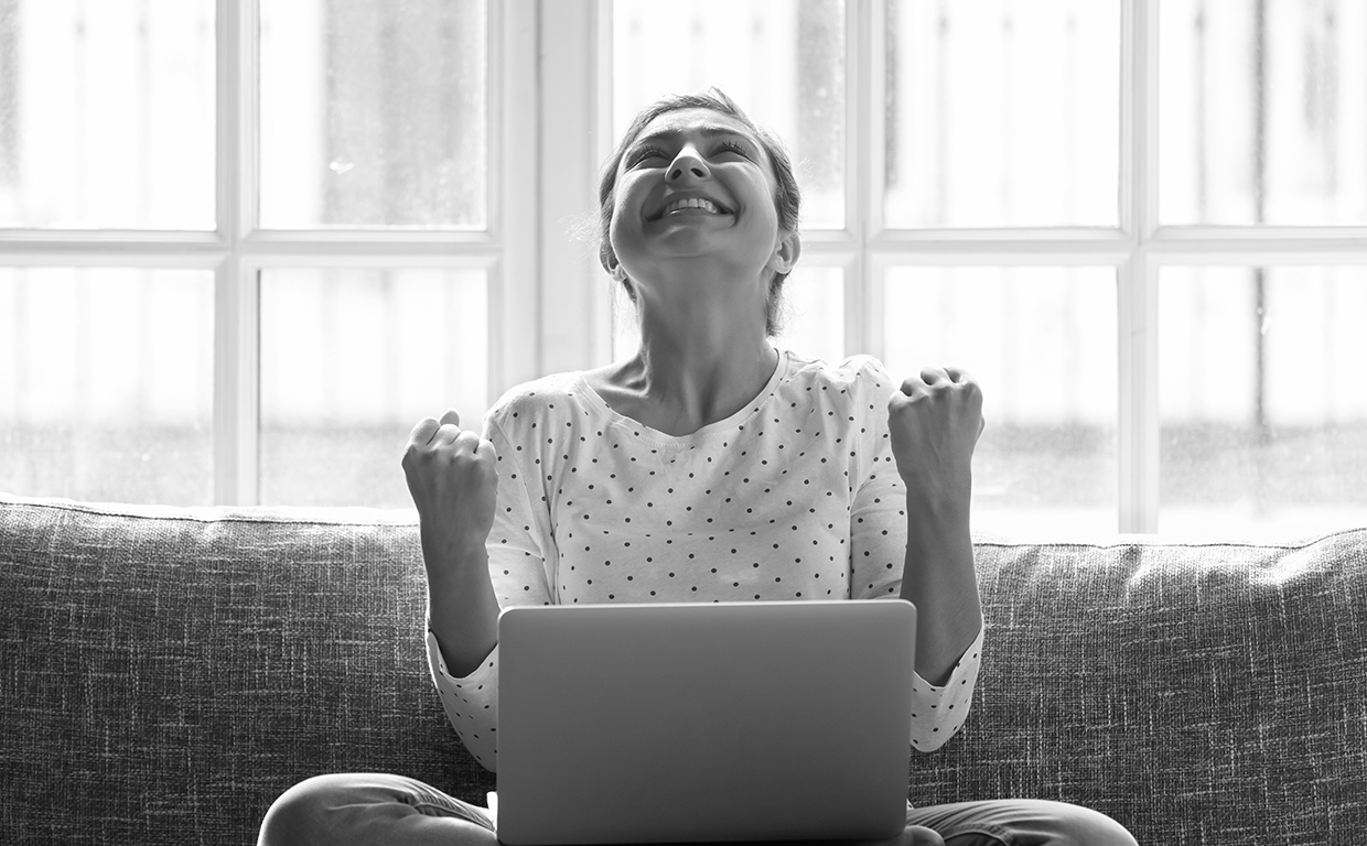 woman celebrating in front of a computer