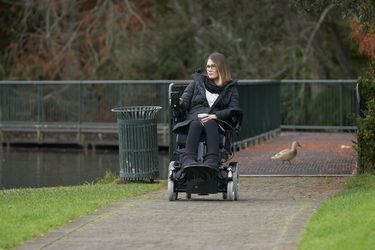 woman sitting in her powerchair in a park