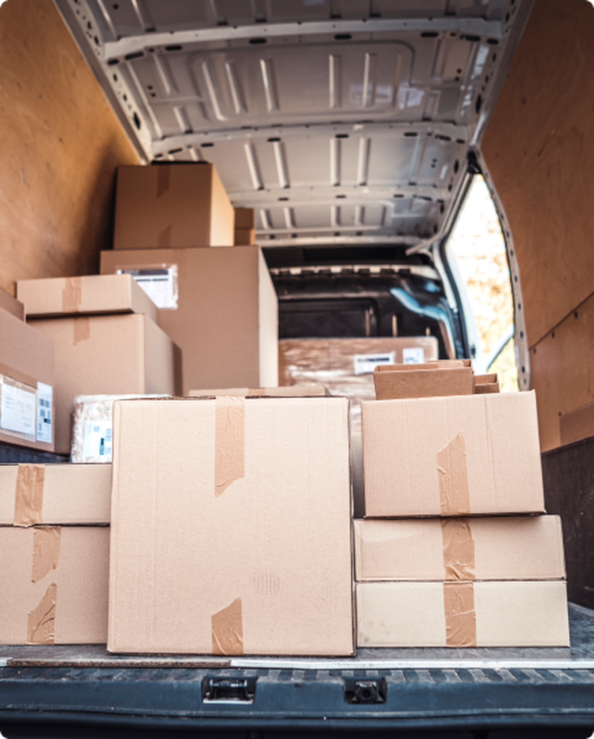 trunk of a cargo van stacked with cardboard boxes
