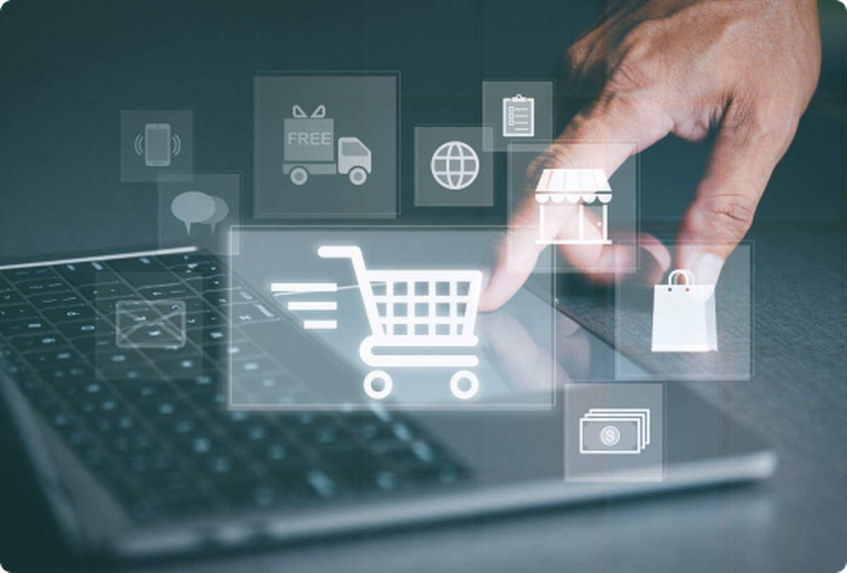 hand using a laptop, several icons related to shopping are floating in the foreground