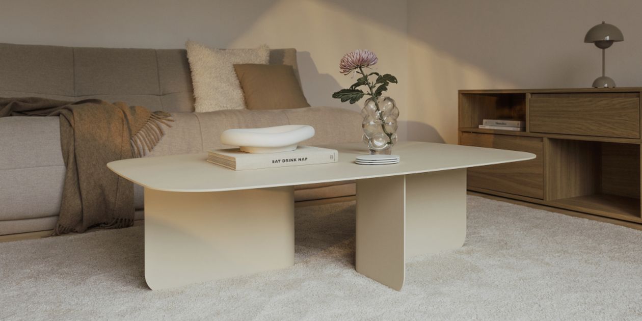 Ein modernes Wohnzimmer mit einem beigen Sofa, einem minimalistischen beigen Couchtisch, Büchern, einer Pflanze in einer Vase und einem Holzregal auf einem Teppichboden.