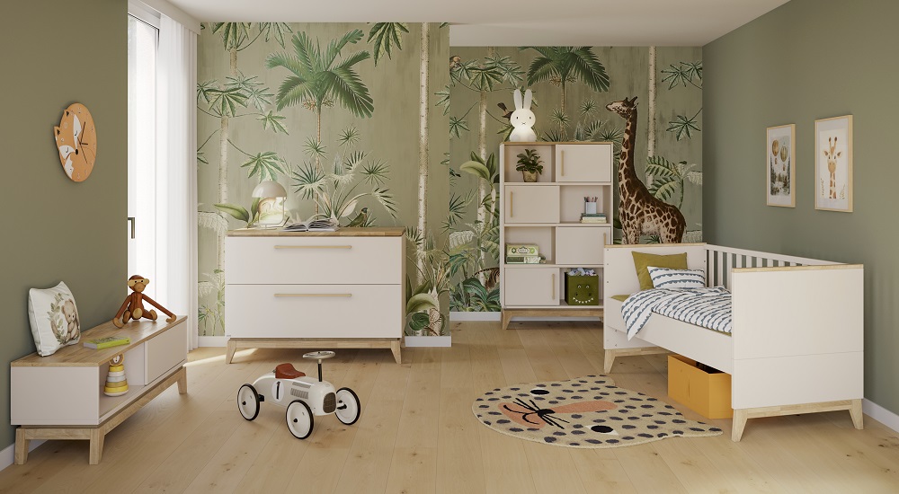 Kinderzimmer im Dschungel-Thema mit einem Bett, Kleiderschrank, Spielzeugauto und einer Giraffentapete. Helle Holzmöbel und grüne Wände sorgen für ein natürliches Flair.