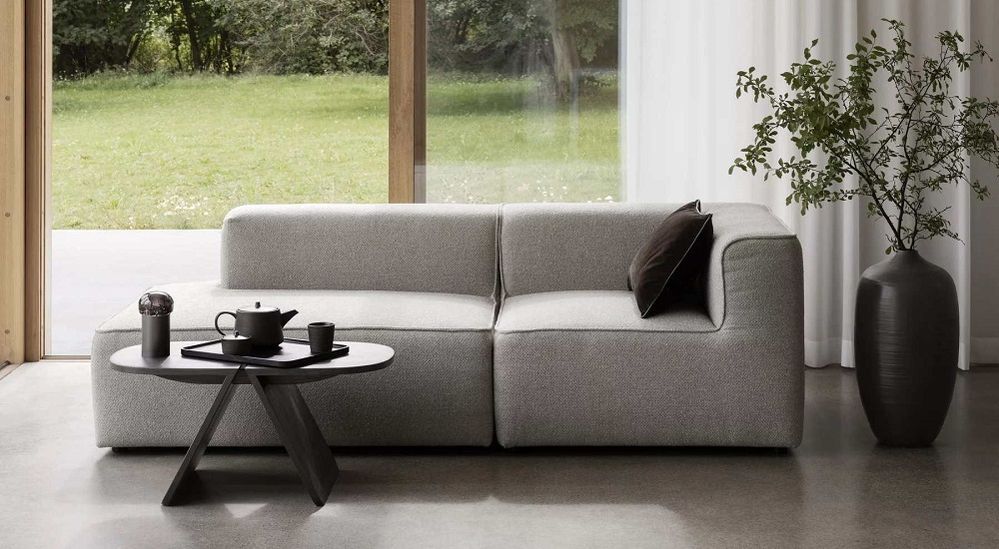 Header: graues Sofa mit schwarzem Couchtisch im Japandi Style