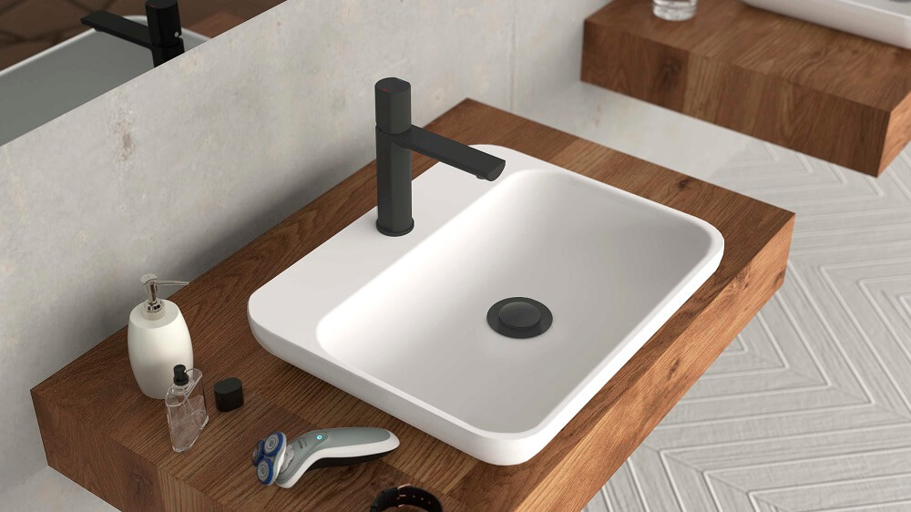 Modernes Badezimmerwaschbecken mit einem rechteckigen weißen Becken, schwarzem Wasserhahn, Holzarbeitsplatte und Toilettenartikeln, einschließlich eines Rasierers und eines Seifenspenders.