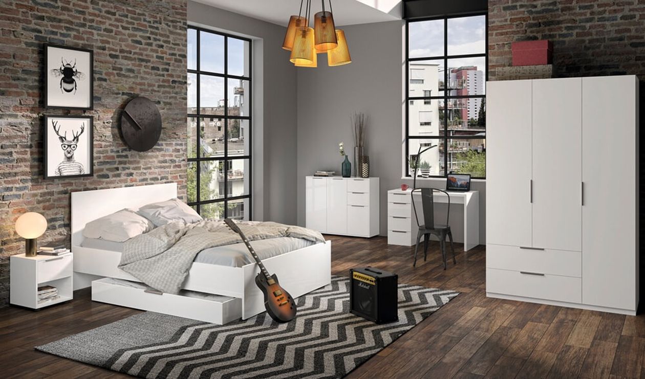 Modernes Schlafzimmer mit Backsteinwänden, weißen Möbeln, einer Gitarre, einem Verstärker und einem Zickzack-Teppich. Große Fenster geben den Blick auf die Stadtlandschaft frei.