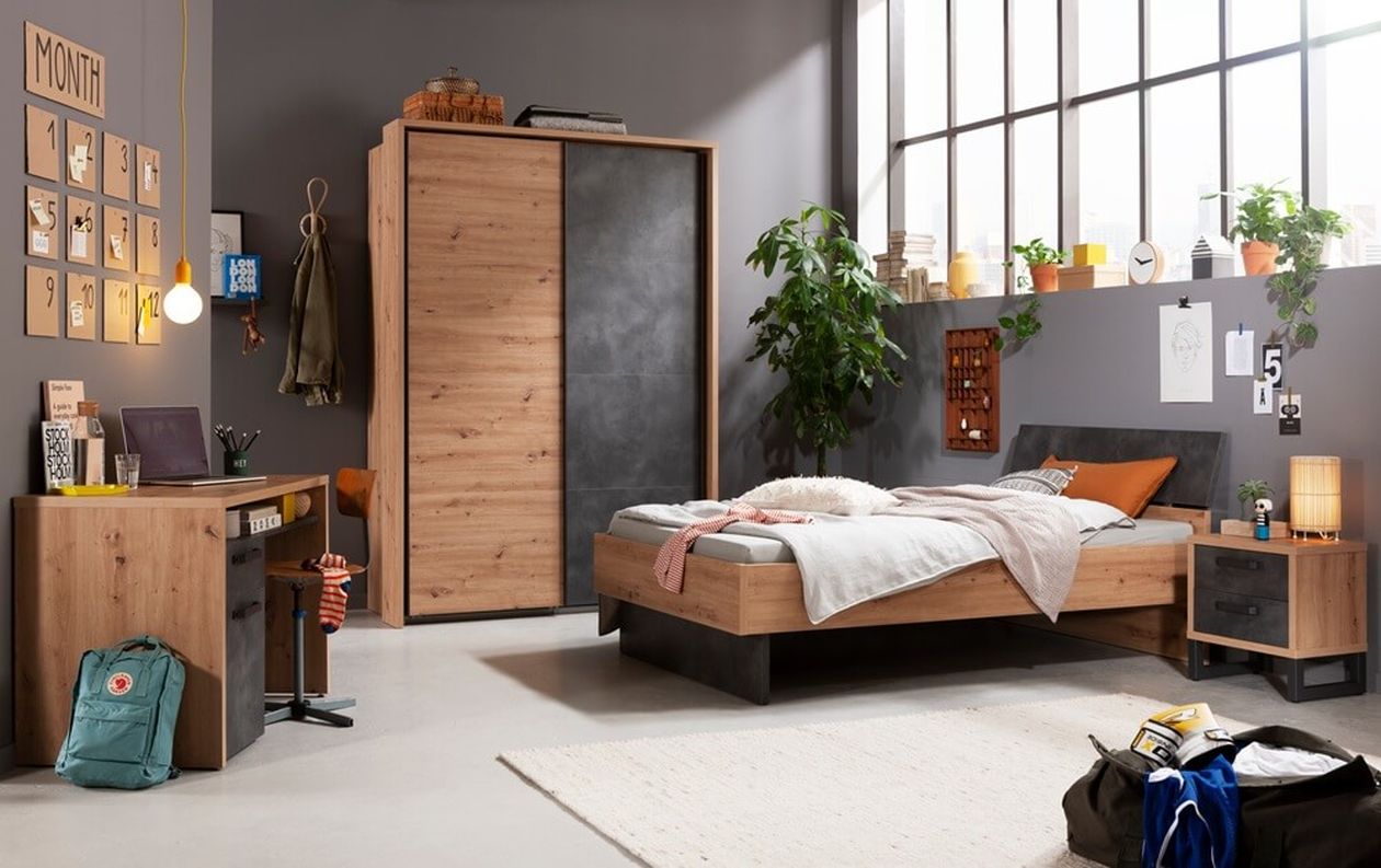 Gemütliches Schlafzimmer mit Holzmöbeln, Bett, Schreibtisch, Kleiderschrank und Pflanzen. Große Fenster und Wanddekoration sorgen für Wärme und Charakter.