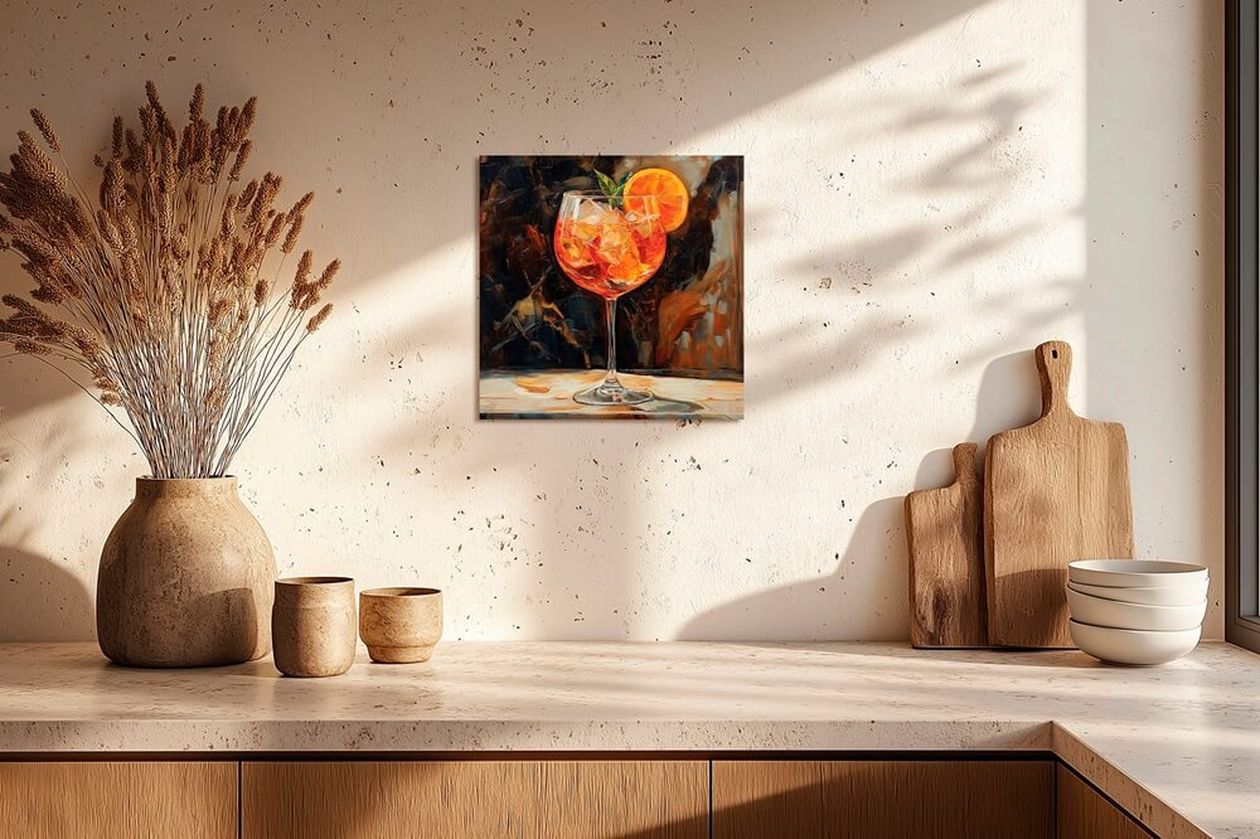 Ein farbenfrohes Wandbild mit einem Cocktailglas hängt über einer hellen Küchenzeile, daneben stehen große Tonvasen und Schneidebretter als Dekoration.