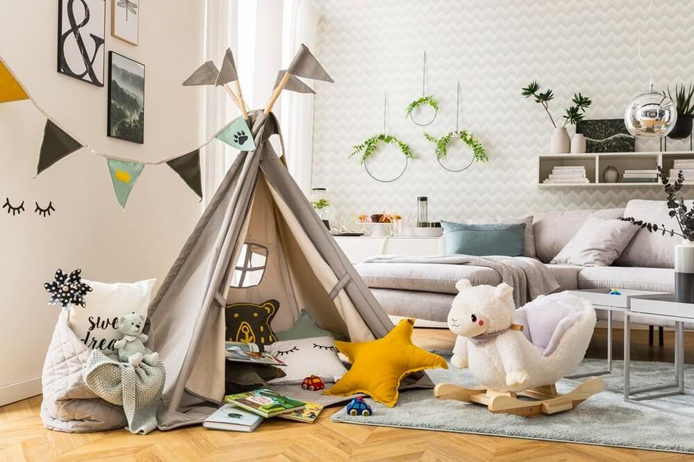 Wohlfühlecke mit Tipi-Zelt, bunten Kissen und Wimpelgirlande – lädt zum Spielen und Lesen im Wohnzimmer ein.