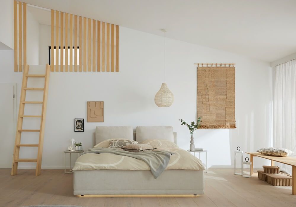 Helles gepolstertes Doppelbett in Beige mit hohem Kopfteil in einem minimalistischen Schlafzimmer mit Holzleiter, Flechtlampe und Wandteppich.