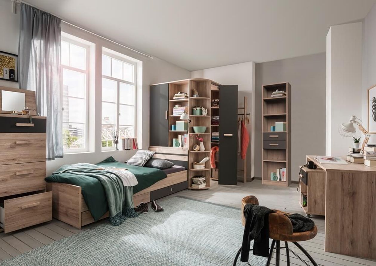 Modernes Schlafzimmer mit Einzelbett, Holzmöbeln, Schreibtisch, Regalen und einem großen Fenster mit Vorhängen. Ein blauer Teppich bedeckt den hellen Holzboden.