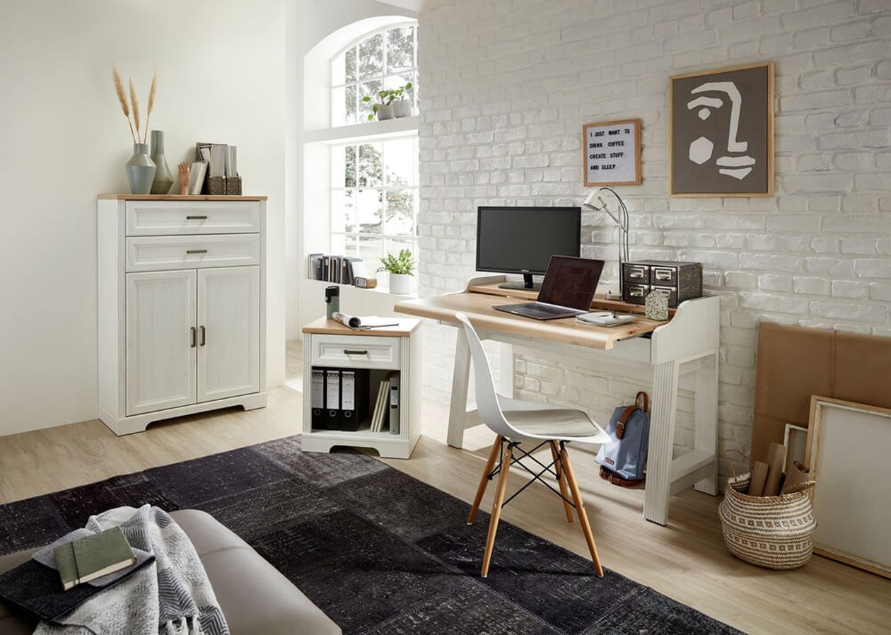 Gemütliches Heimbüro mit einem Holzschreibtisch, einem Computer, einem weißen Stuhl, einem Schrank und Dekor an einer weißen Ziegelwand in der Nähe eines großen Fensters.