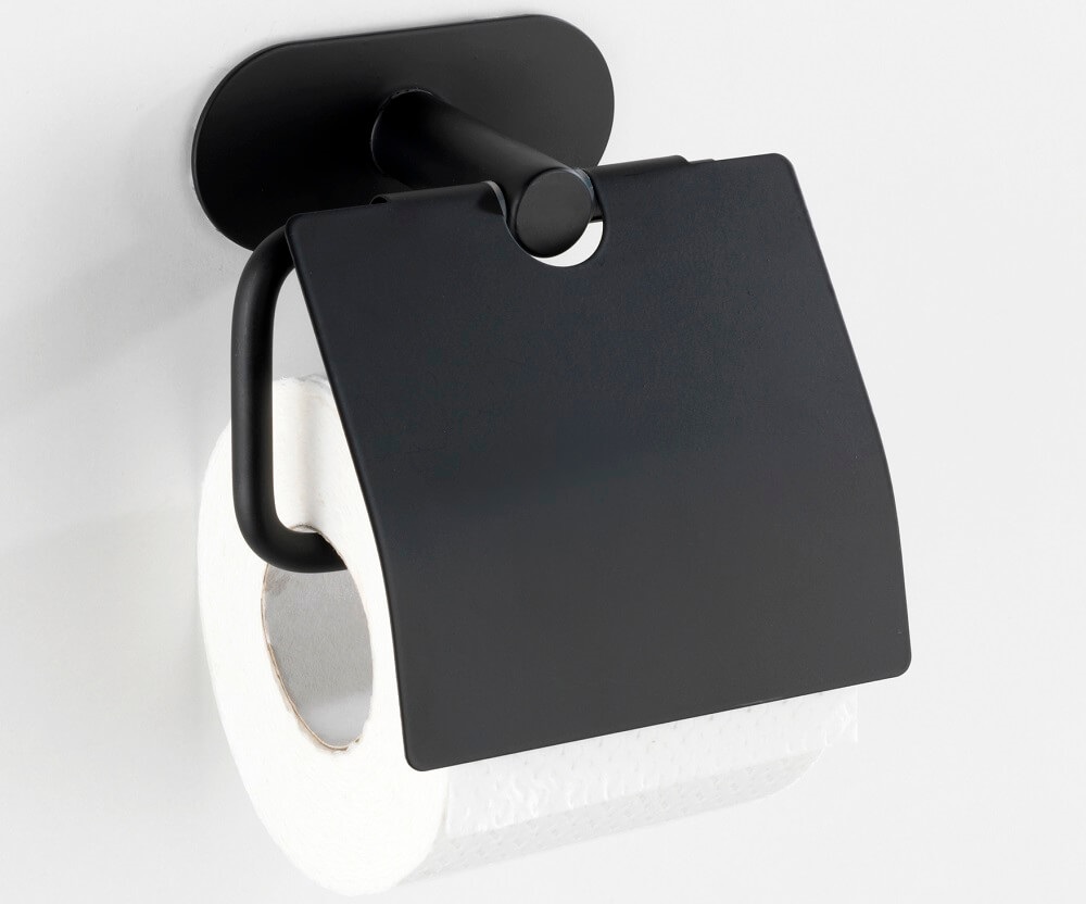Schwarzer Toilettenpapierhalter mit einer Rolle weißen Toilettenpapiers, an der Wand montiert. Der Halter hat ein schlankes, modernes Design mit einer Abdeckung.