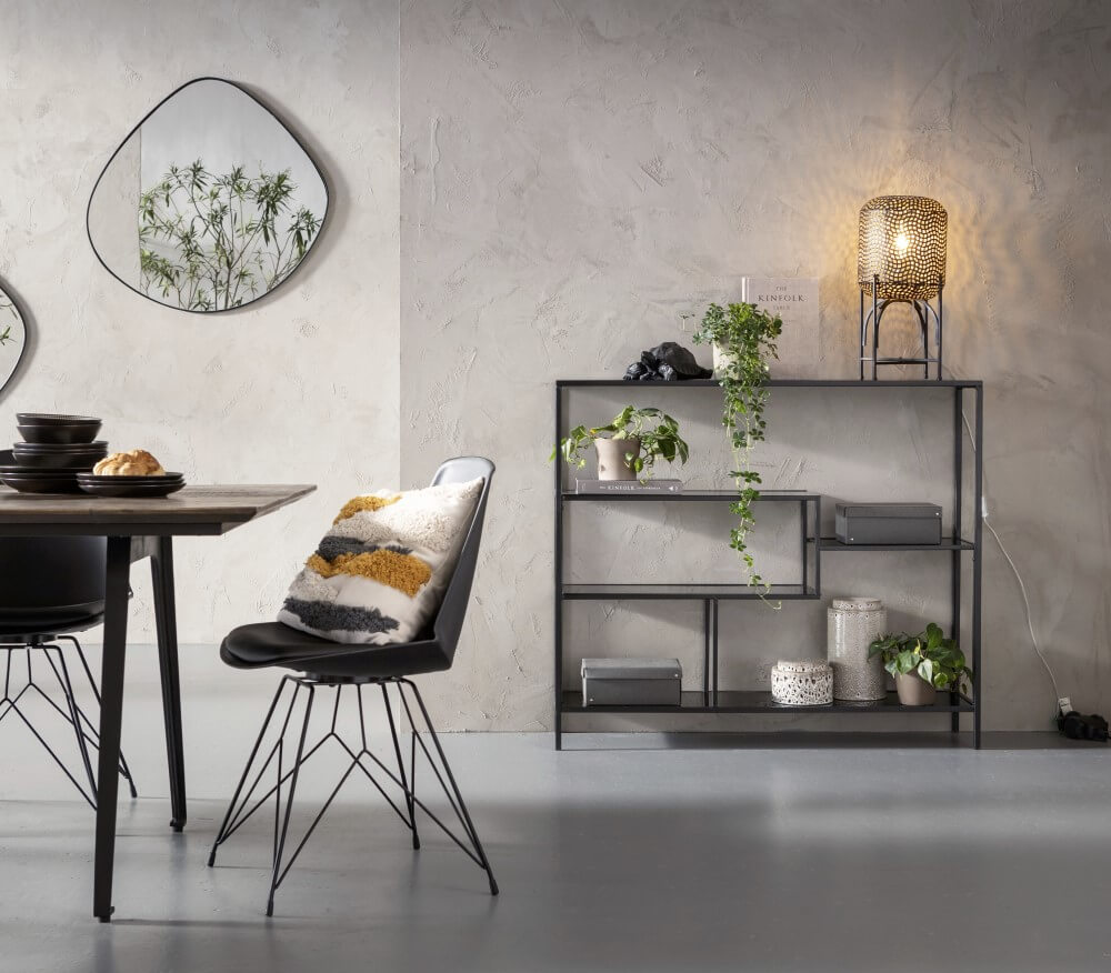 Modern dining area with a black chair and table, geometric mirrors and a shelf with plants.