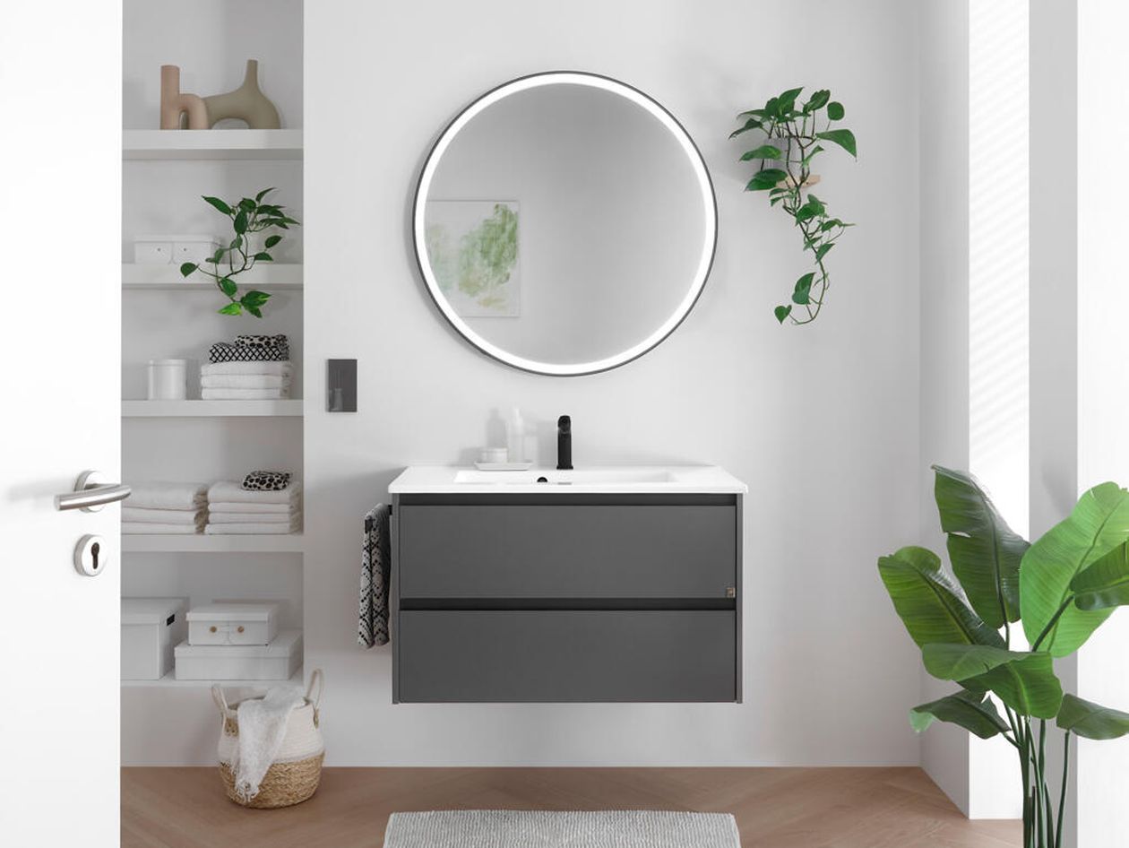 Modernes Badezimmer mit rundem Spiegel, schwebendem Waschtisch und Pflanzen. Minimalistisches Dekor mit Regalen und einem geflochtenen Korb auf dem Boden.