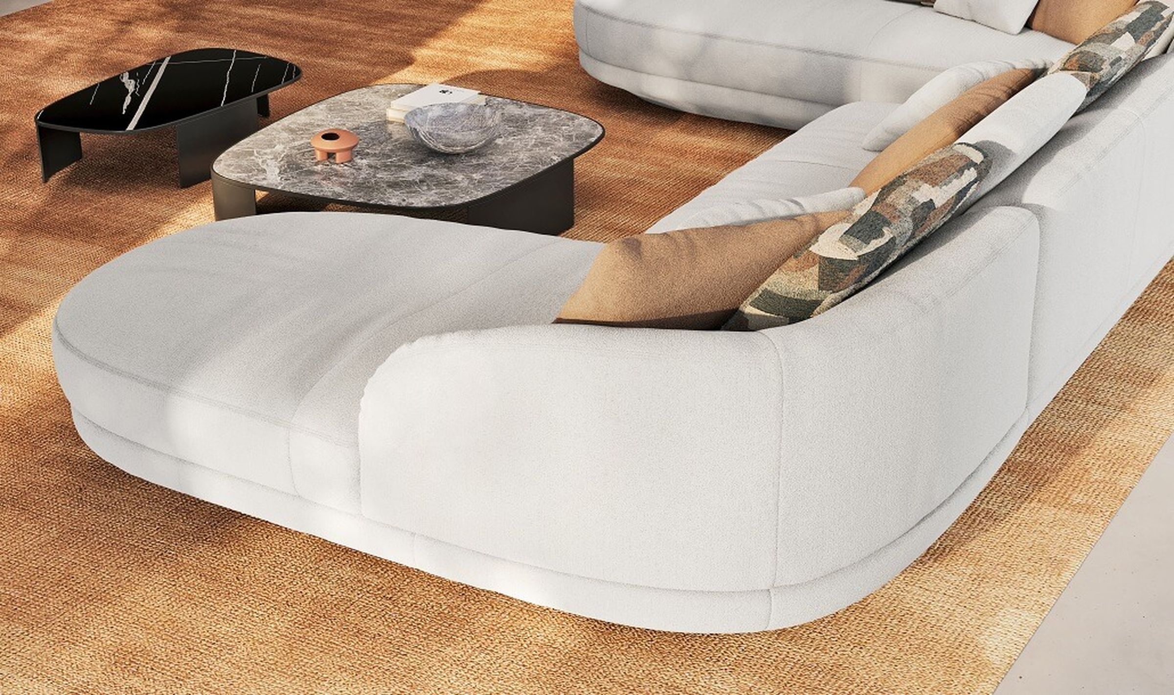 Modernes Wohnzimmer mit einem geschwungenen weißen Sofa, gemusterten Kissen, schwarzen und grauen Marmor-Couchtischen auf einem gewebten Teppich.