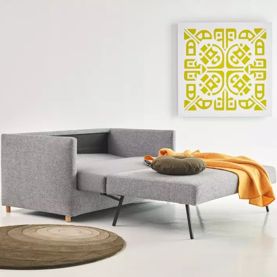 Schlafsofa Olan der Marke Innovation Living aus grauem Stoff mit Ausziehfunktion in einem modernen Raum
