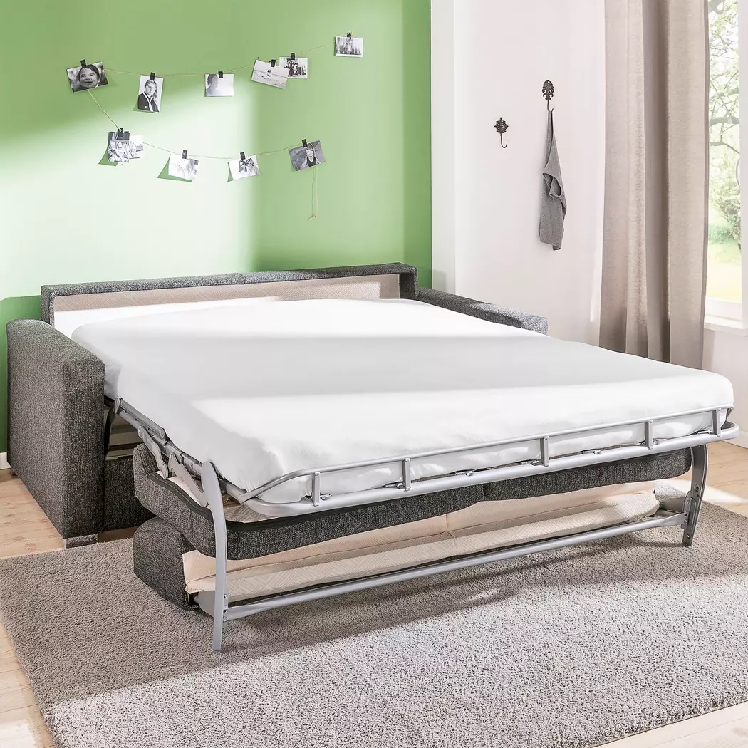 Schlafsofa CLEO aus grauem Stoff mit einer Matratze und einem Lattenrost in einem modernen Zimmer