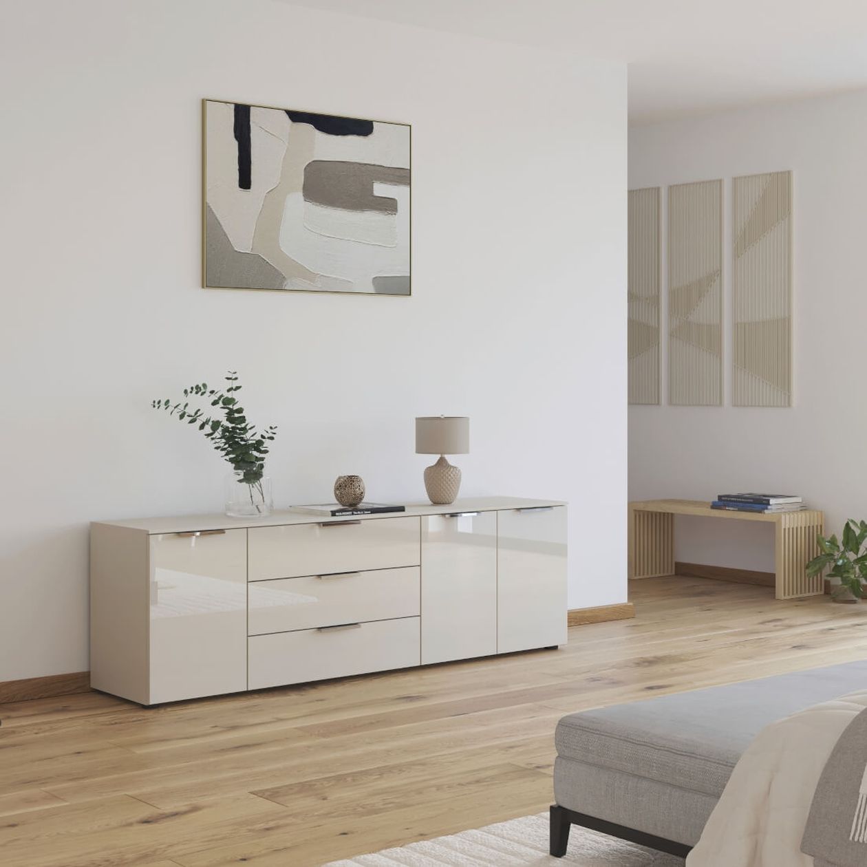 Hellgraue Kommode, auf der eine Vase und eine Tischlampe steht. Darüber ein abstraktes Bild mit geometrischen Formen.