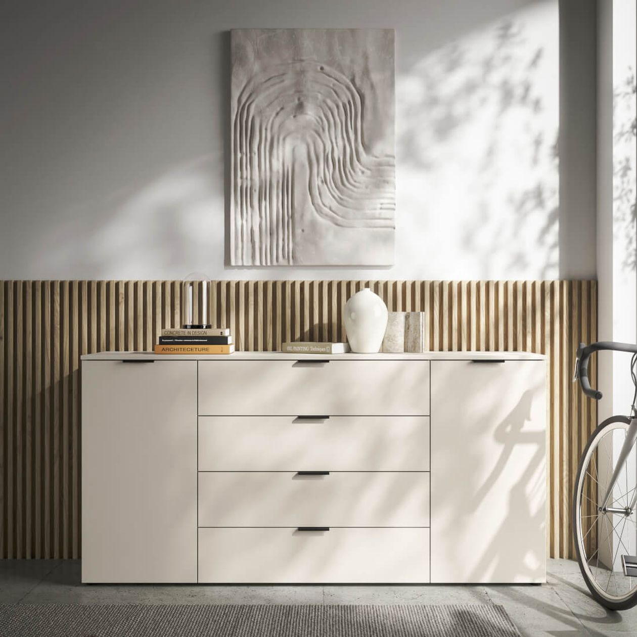 Hellgraues Sideboard vor einer hölzernen Lamellenwand. Darüber ein gemaltes Bild mit einem abstrakten Motiv.