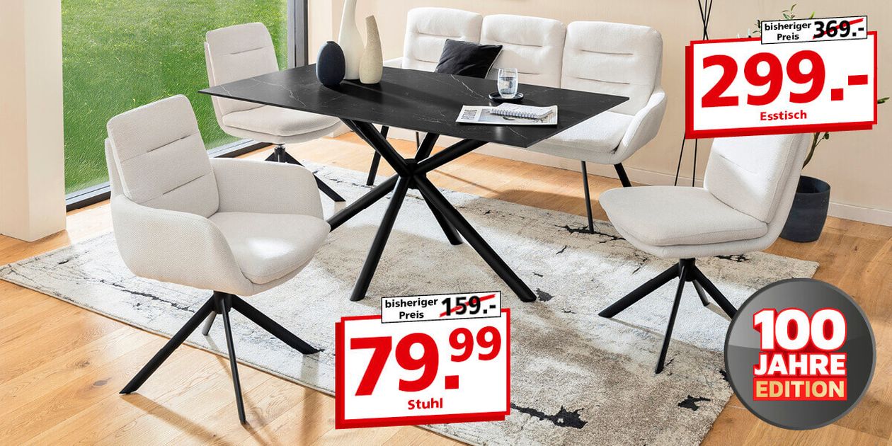 Modernes Esstisch-Set mit schwarzem Tisch und weißen, gepolsterten Stühlen auf einem gemusterten Teppich. Preisschilder heben Rabatte hervor.