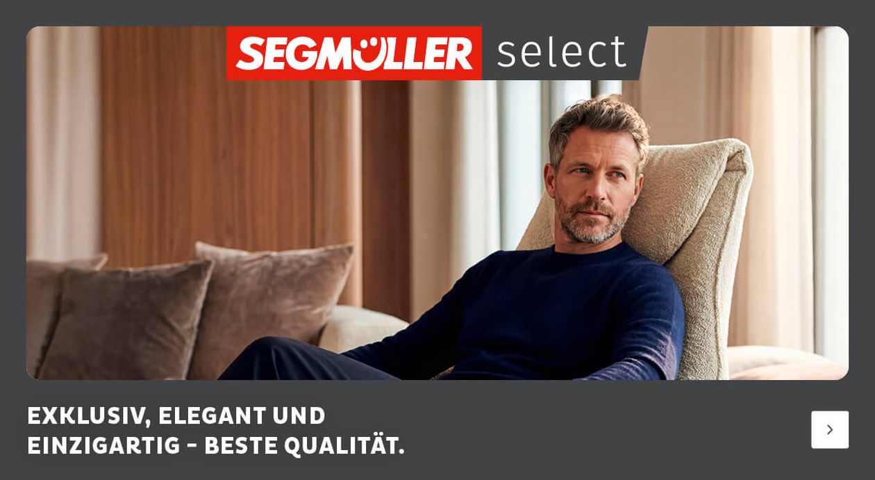 Ein Mann in einem blauen Pullover sitzt bequem auf einem beigen Stuhl. Die Select-Werbung wirbt mit Exklusivität und Qualität.